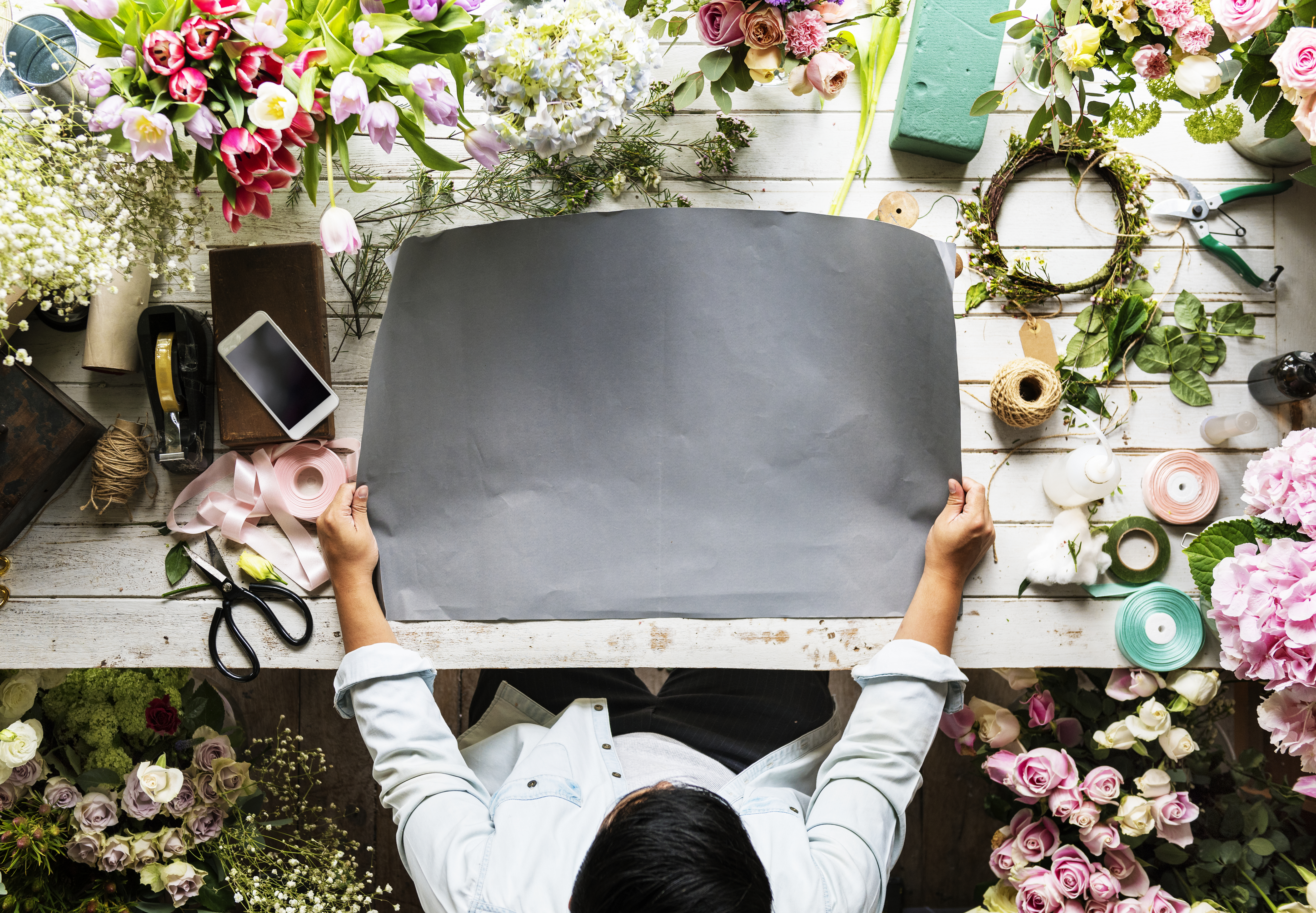 Florist Showing Empty Design Space Paper on Wooden Table