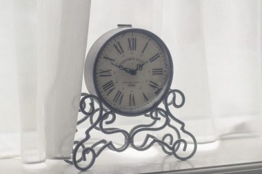 Metal clock in window_Tomasz Bazylinski_Stocksnap